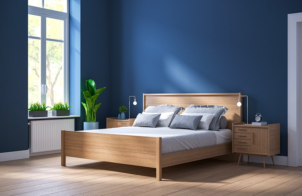 Camera da letto con pareti blu, parquet e letto in legno