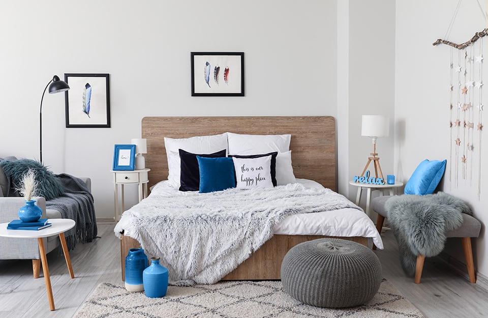 Camera da letto con molti accessori e complementi. La tonalità dominante è il bianco e il colore d'accento è il blu