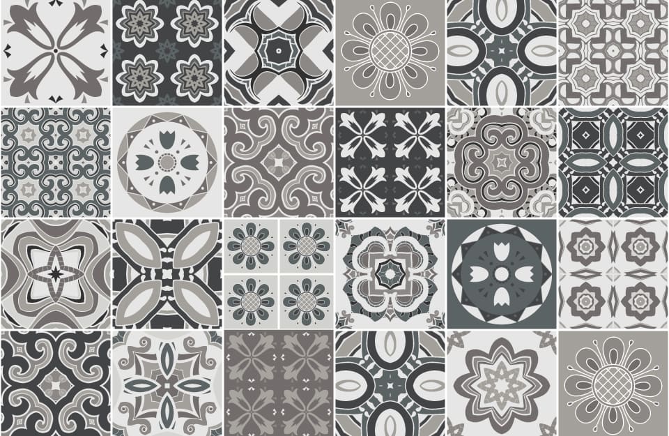 Mosaico di piastrelle, ciascuna con un pattern differente in diverse tonalità di grigio, tortora e antracite