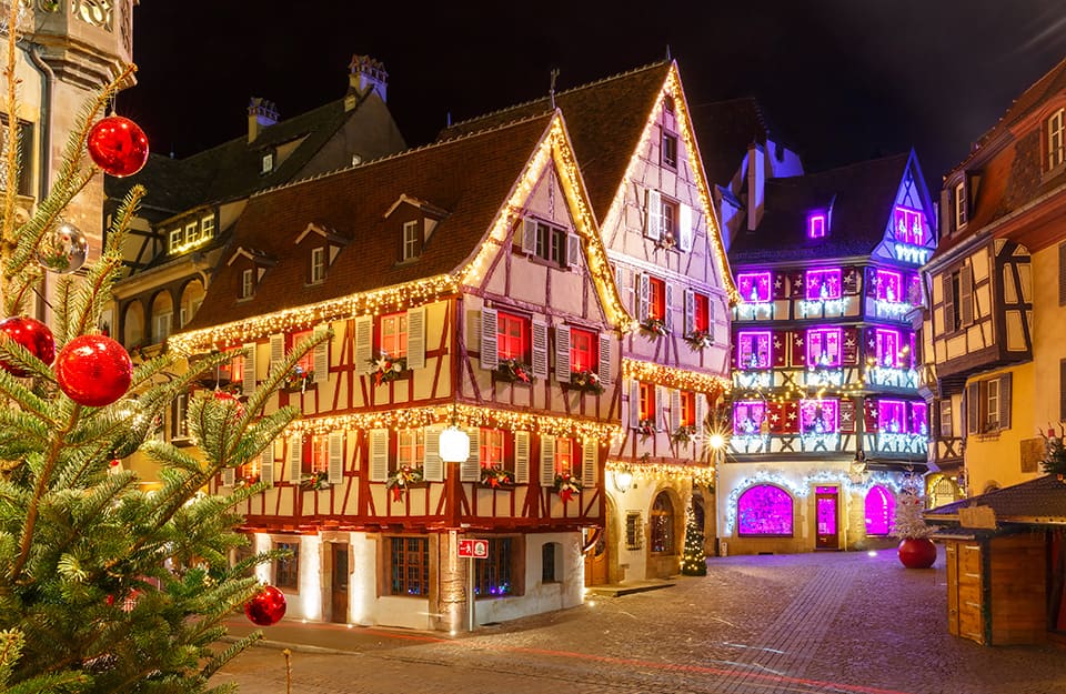 Vista notturna di Colmar, in Francia, illuminata dalle luci natalizie che mettono in risalto i caratteristici colori “da fiaba” degli edifici