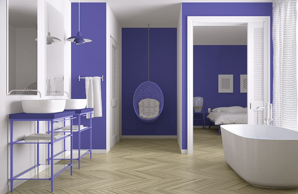 Bagno moderno e luminoso con parquet in legno, pareti bianche e colori d'accento (su parte delle pareti) nel colore dell'anno 2022 Very Peri