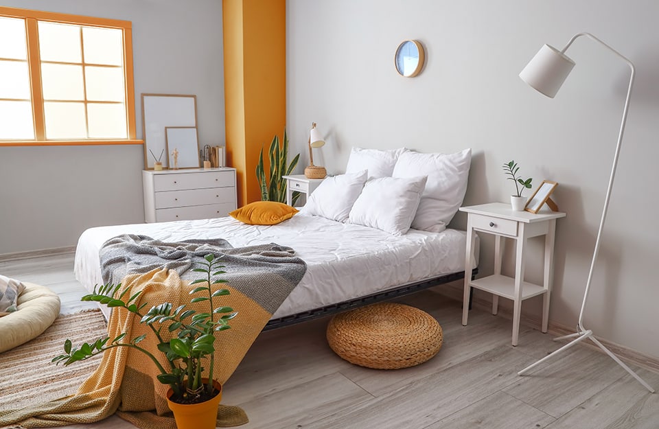 Camera da letto con pareti grigie e toni d'accento arancioni