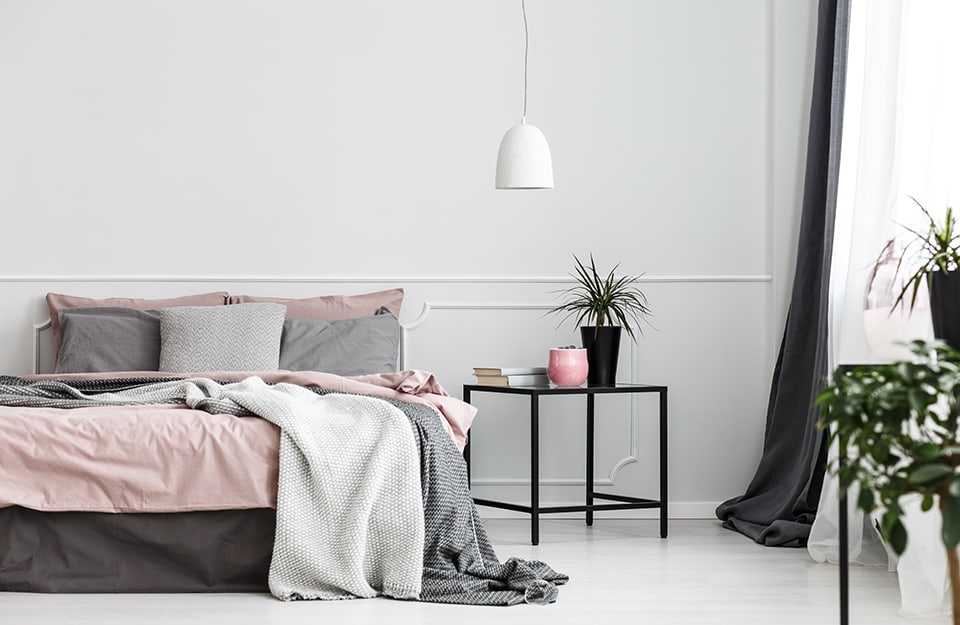 Camera da letto minimale con pareti grigie e accenti rosa