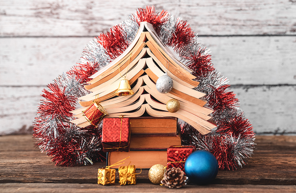 Un albero di Natale formato da libri aperti, palline e festoni