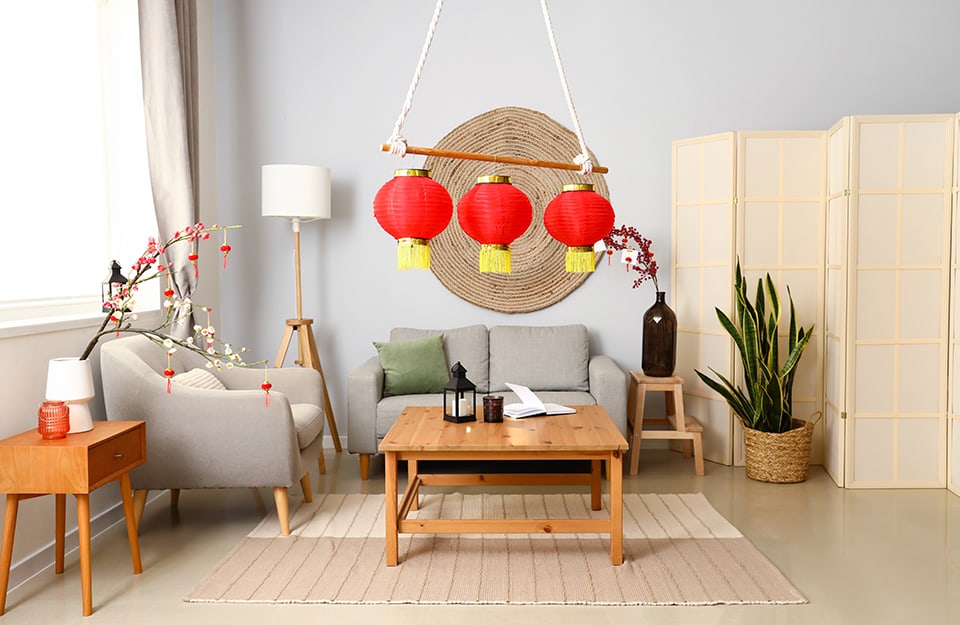Un salotto minimal, decorato con alcuni elementi tipici cinesi, come lampade in carta di riso e paravento