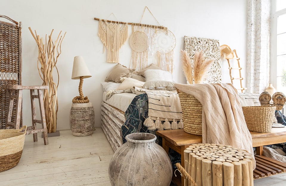 Una luminosa camera da letto con un'abbondanza di decorazioni e accessori etnici dai colori naturali