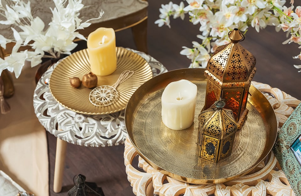 Angolo di un salotto decorato con accessori arabeggianti, tra cui lampade e piatti marocchini