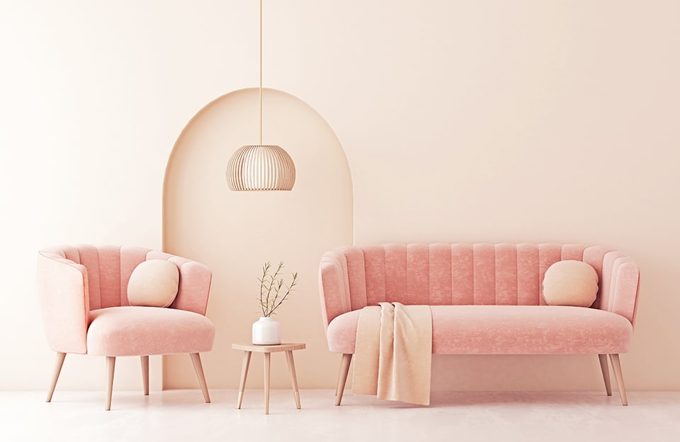 Interno minimale tutto sui toni del rosa pastello, applicato a muri, sofà, cuscini e coperte