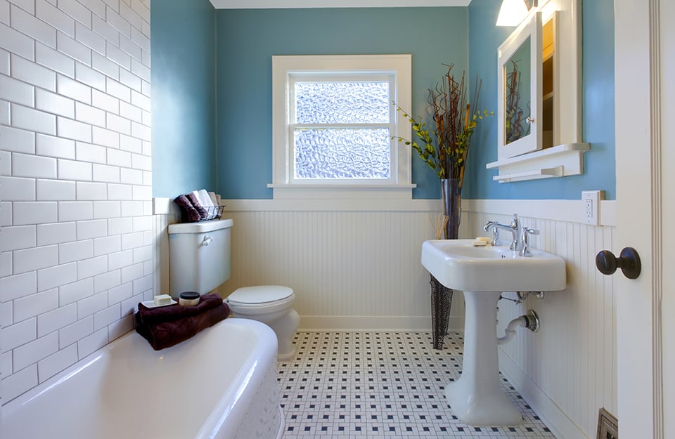 Bagno sui toni del blu pastello e del bianco, con pareti verniciate e piastrelle, sanitari e pavimenti bianchi