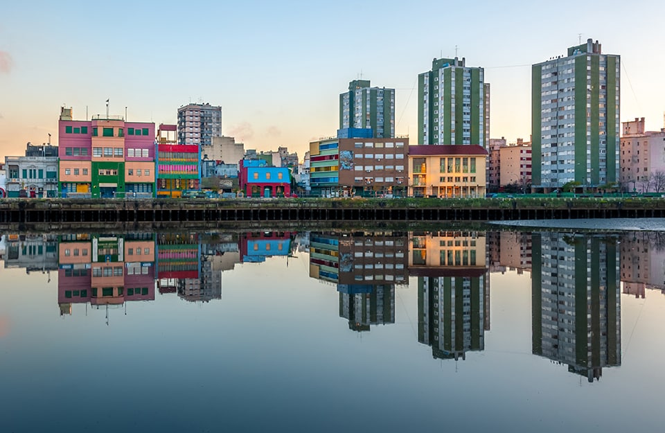 Vista dal fiume sul quartiere La Boca di Buenos Aires, con gli alti edifici moderni a destra e il basso e coloratissimo Caminito a sinistra