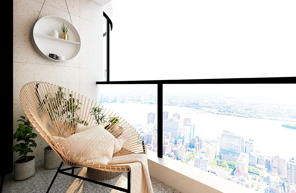 Un balcone con vista dall'alto su una grande città, arredato con sedia di design in vimini e una mensola rotonda appesa al muro