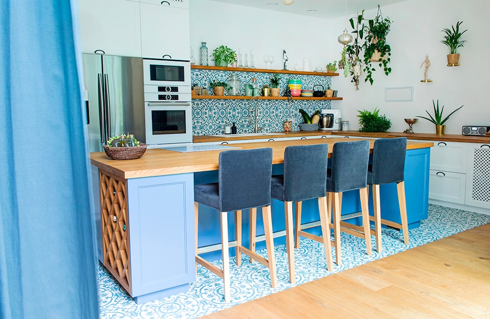 Cucina in stile mediterraneo sui toni dell'azzurro e del legno naturale, con isola centrale e quattro sgabelli