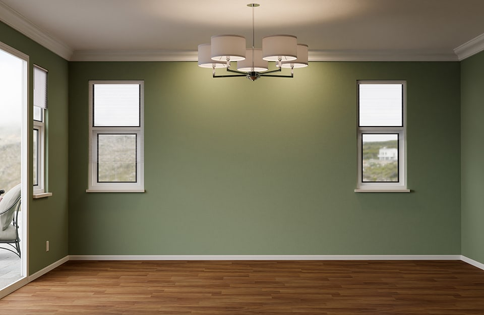 Stanza vuota di un appartamento con pareti verdi, soffitto bianco con grande lampadario e pavimento in parquet
