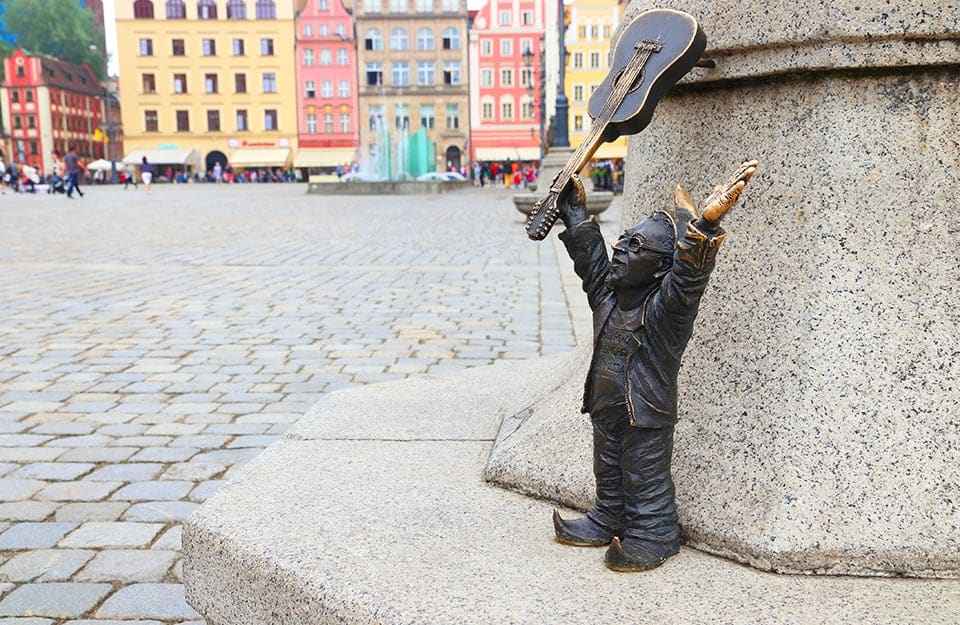 Una delle tipiche statuine di gnomi di Breslavia, in Polonia, con sullo sfondo la Piazza del Mercato