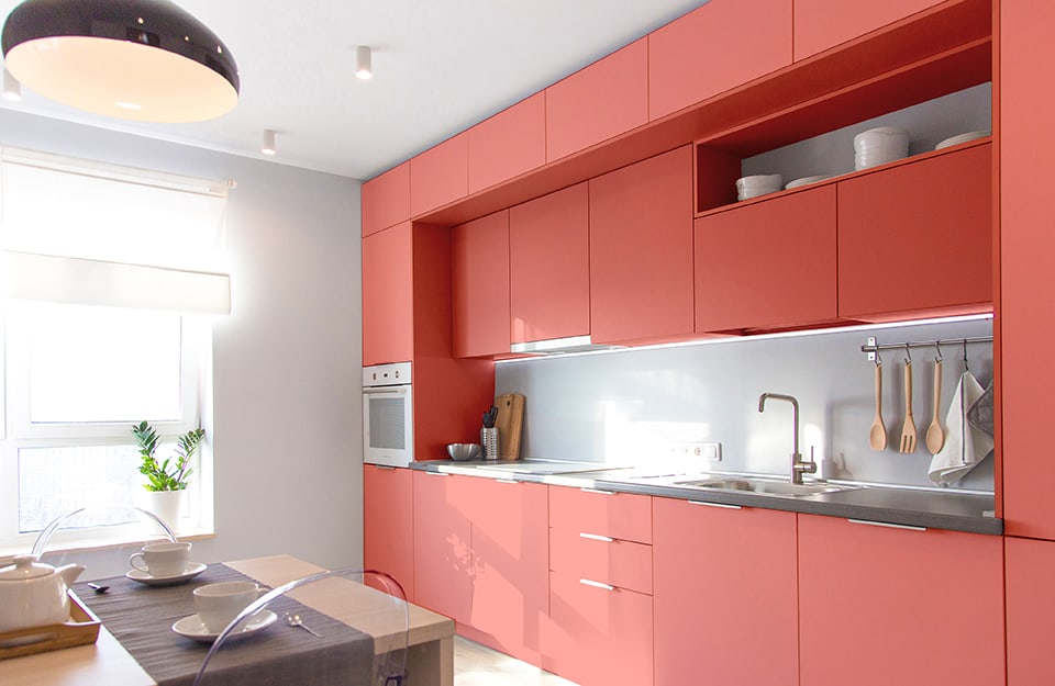 Cucina modulare moderna sui toni del rosa antico, in una stanza luminosa sul bianco