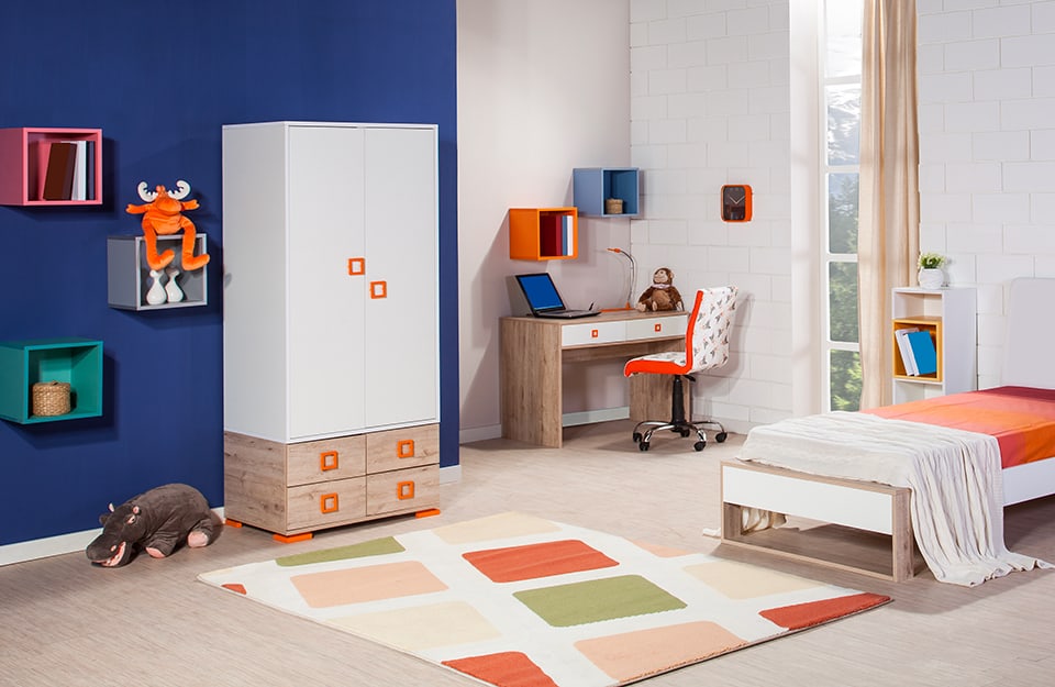 Multicoloured children's bedroom. White walls and a blue wall with orange, grey, green and light blue shelves, multicoloured carpet, bed with coloured bed linen, wooden, white and orange desk and wardrobe in the same colours;