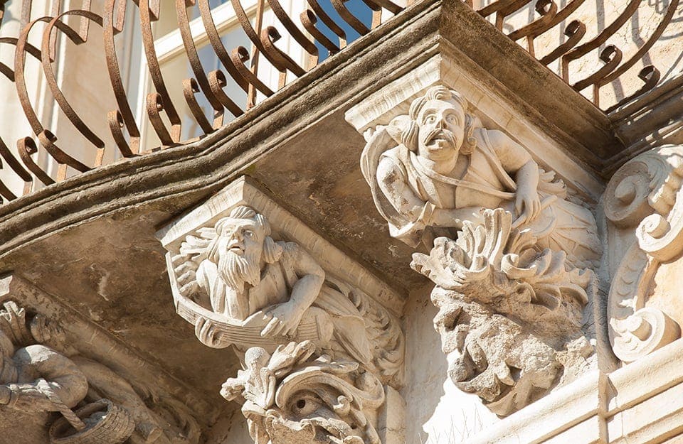 Veduta di alcuni tipici mascheroni barocchi sotto i balconi di Palazzo Cosentini a Ragusa Ibla