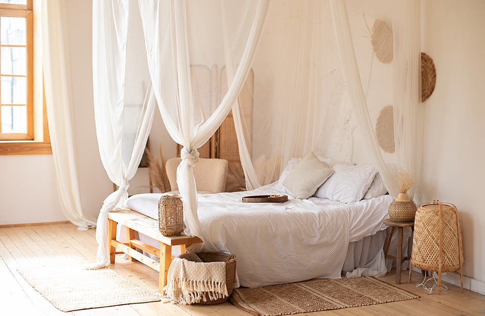 Camera da letto in stile Mérida in una casa messicana. La stanza è luminosa e su calde tonalità chiare. Il letto ha il baldacchino
