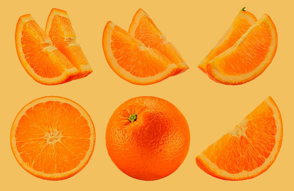 Delle arance intere, tagliate e a fette, su sfondo arancione