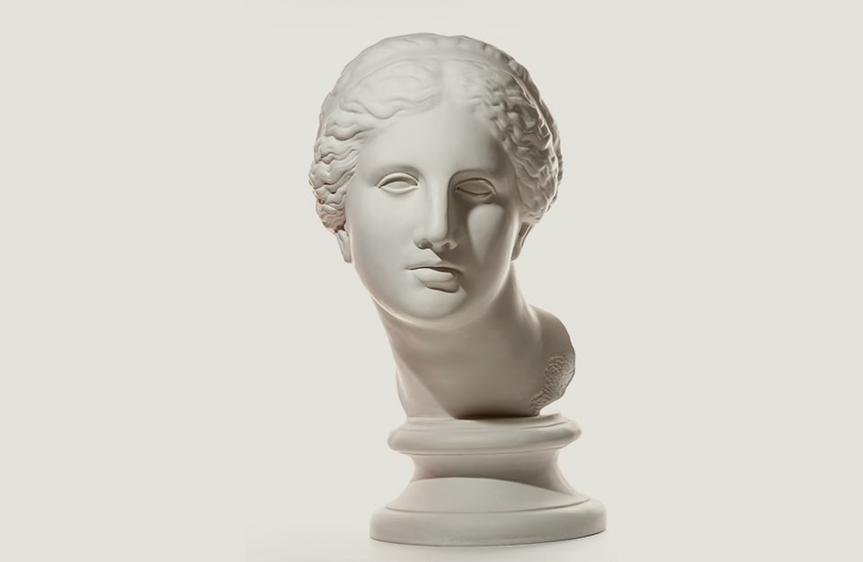 La testa femminile di una statua di marmo su sfondo bianco antico