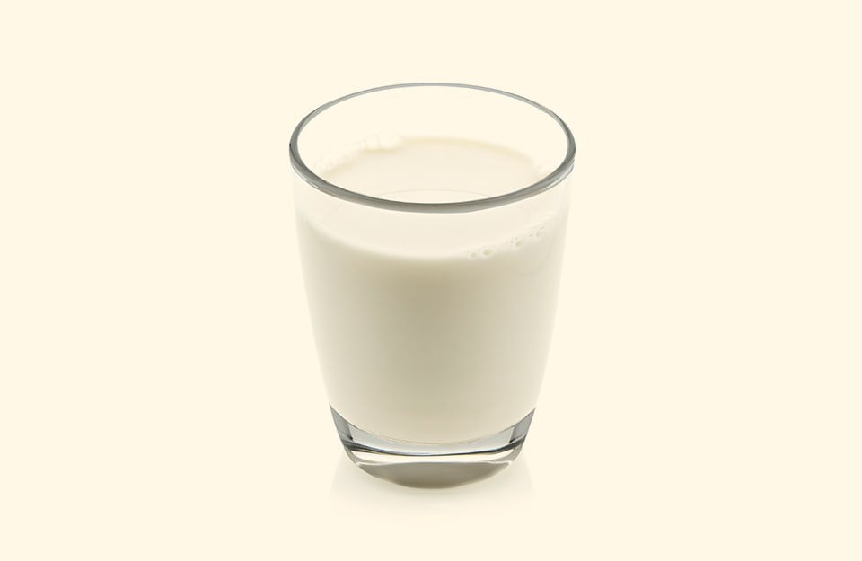 Un bicchiere di latte su sfondo bianco latte