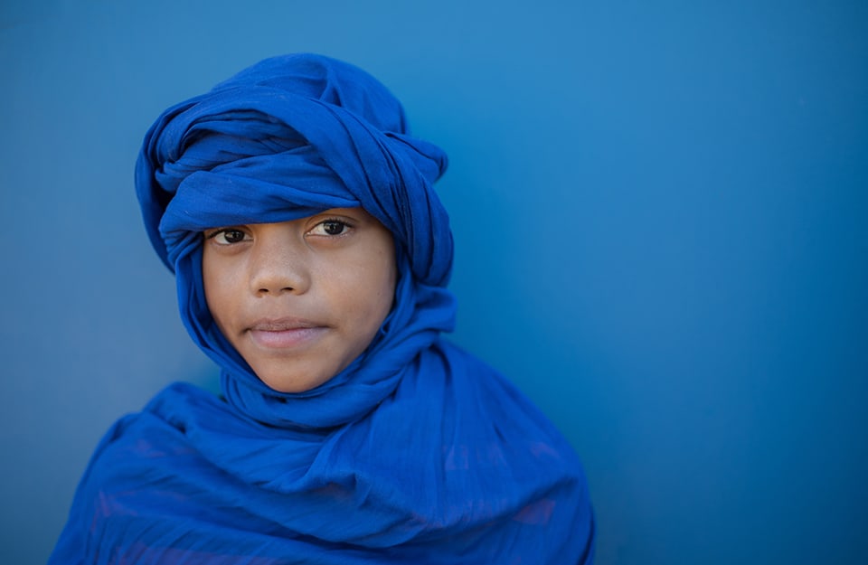 Un bambino tuareg con il tradizionale “burnus”, l'abito di lana di colore blu, e il “taghelmoust”, il copricapo dello stesso colore