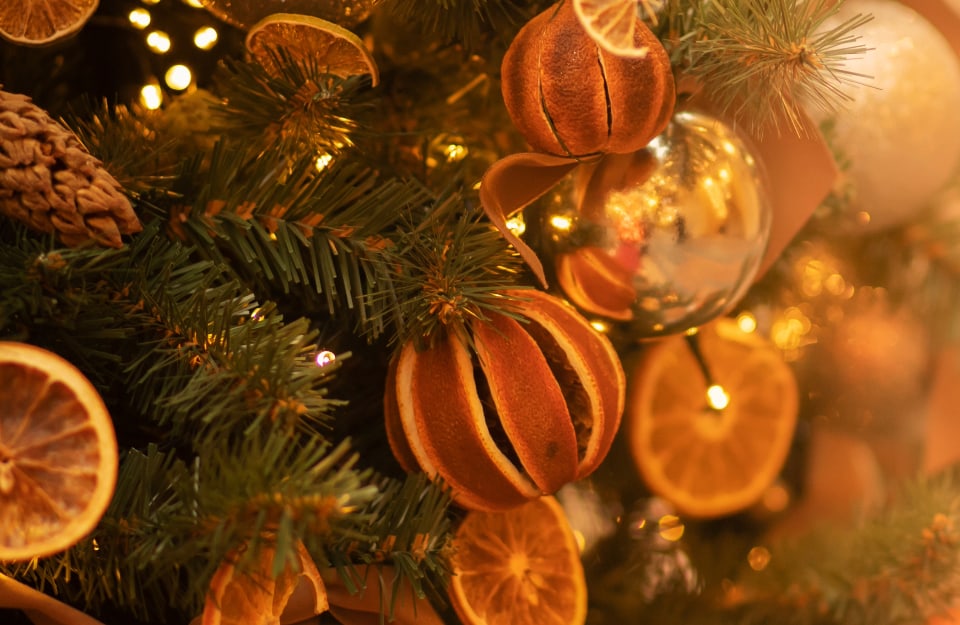Dettaglio di alcune decorazioni di un albero di Natale, realizzate con arance secche e palle di Natale dai colori autunnali