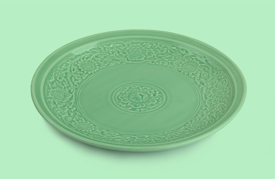 Un piatto in ceramica di color celadon, su sfondo verde chiaro