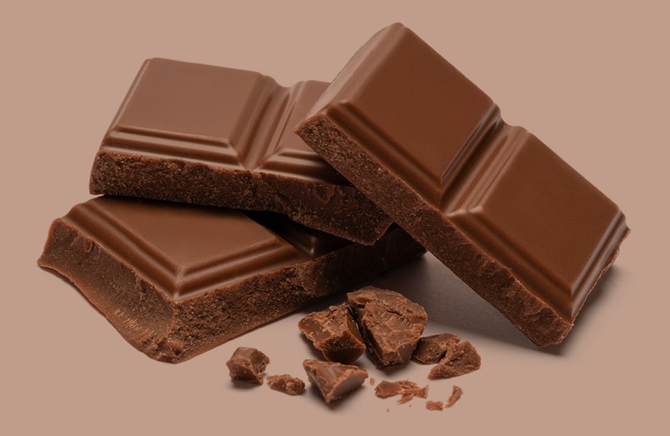 Dei quadrati di cioccolato su sfondo marrone