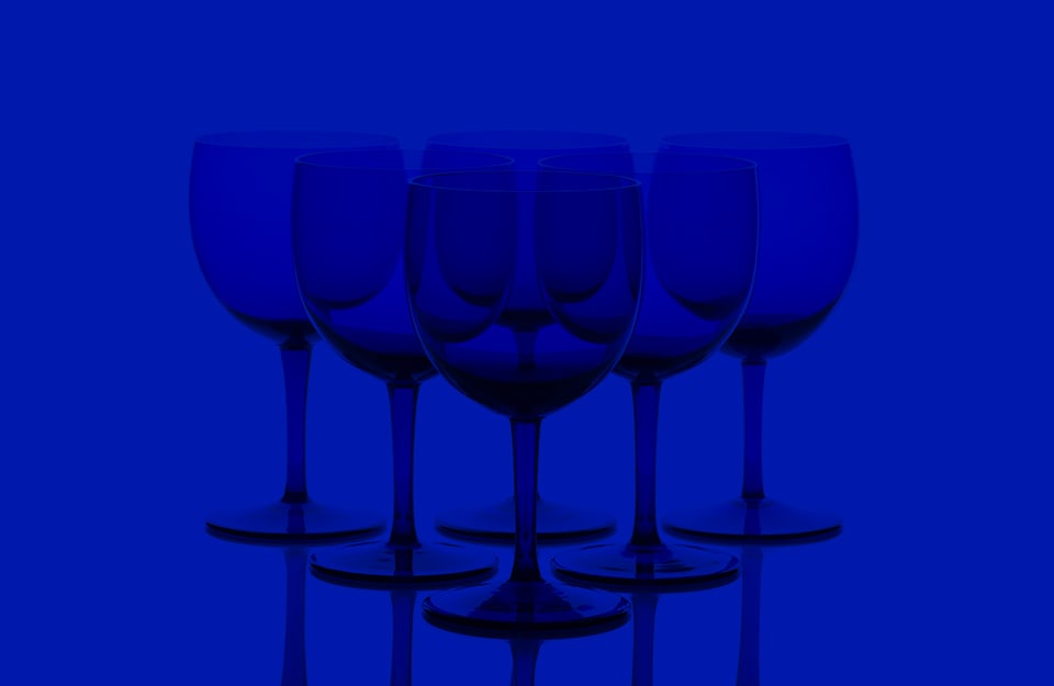Una composizione con bicchieri di vetro a calice color cobalto su sfondo blu