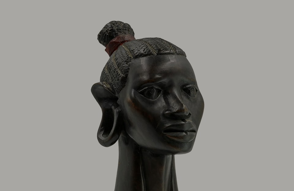 Una statuetta in legno d'ebano, che rappresenta il volto di una donna africana