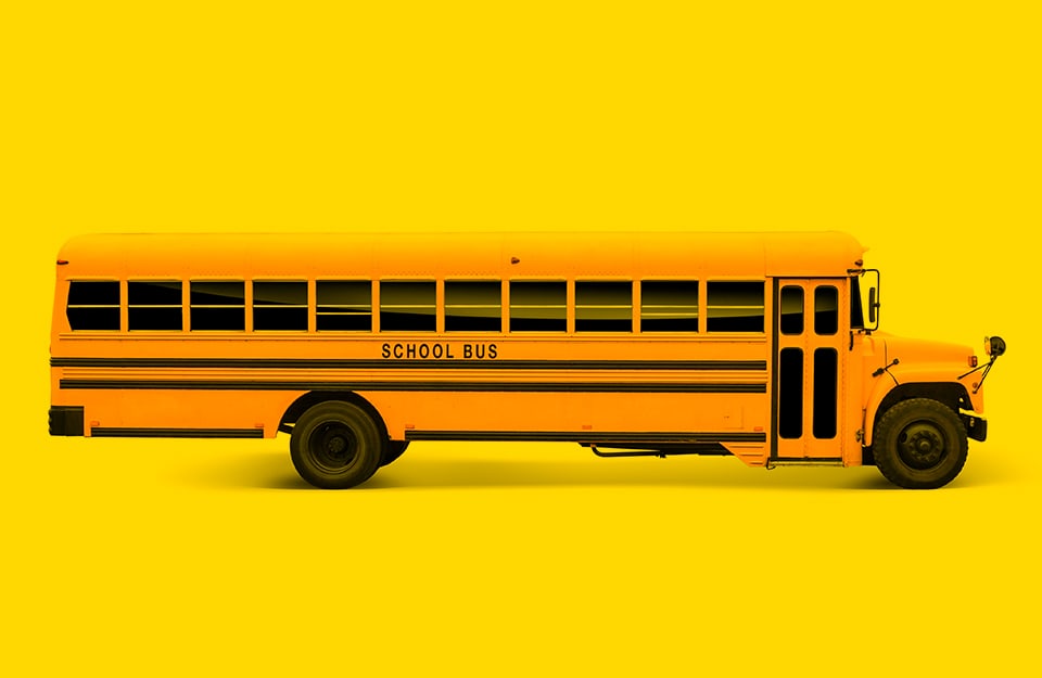 Uno scuolabus giallo statunitense su sfondo giallo scuolabus