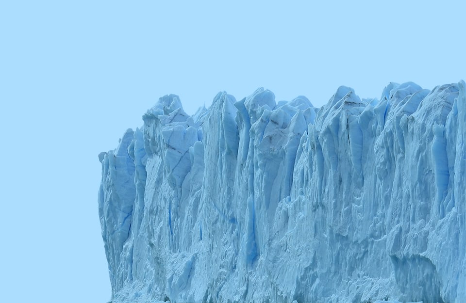 Parte di un iceberg molto frastagliato, su sfondo azzurro