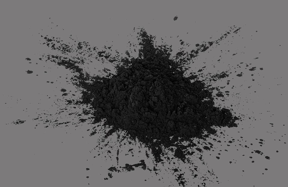 Del pigmento nero in polvere, su sfondo grigio