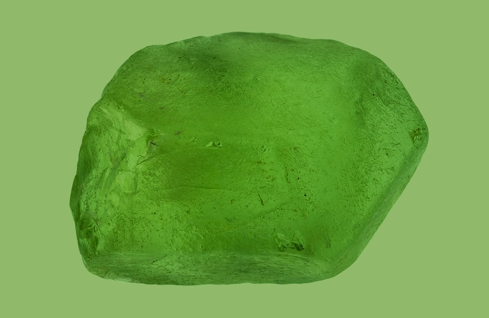 Un minerale di olivina su sfondo color olivina