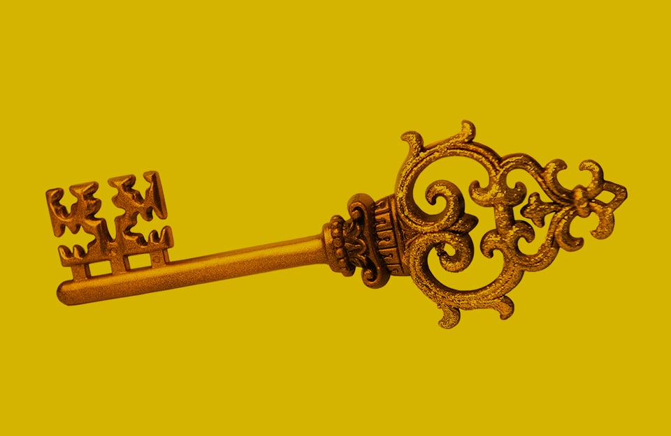 Una chiave dorata su sfondo color oro vecchio