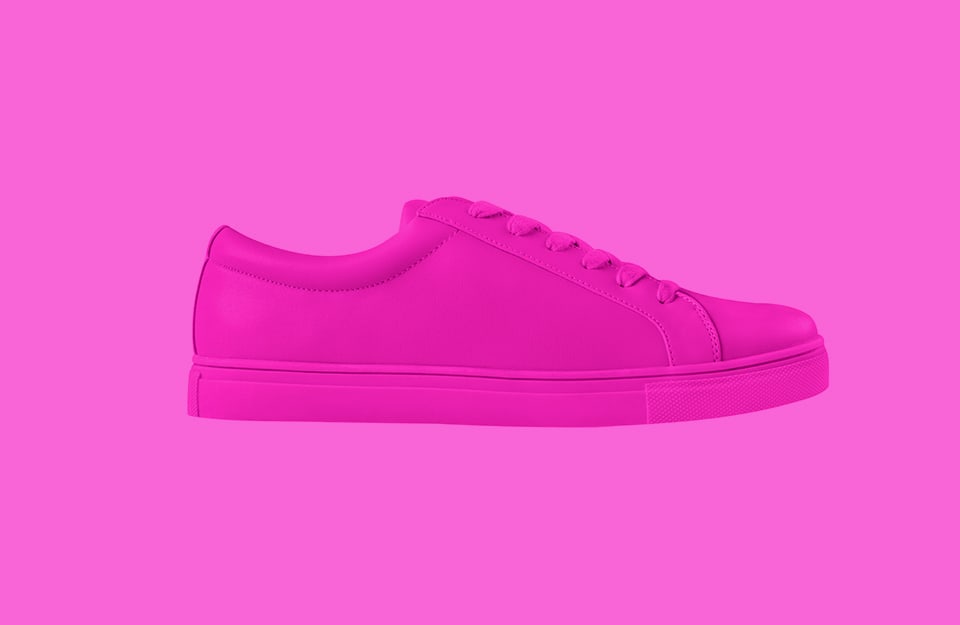 Una sneaker rosa shocking su sfondo dello stesso colore