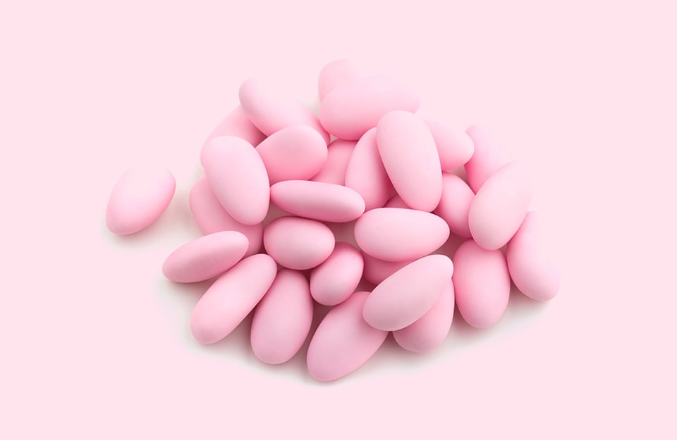 Un mucchio di confetti rosa su sfondo rosa confetto
