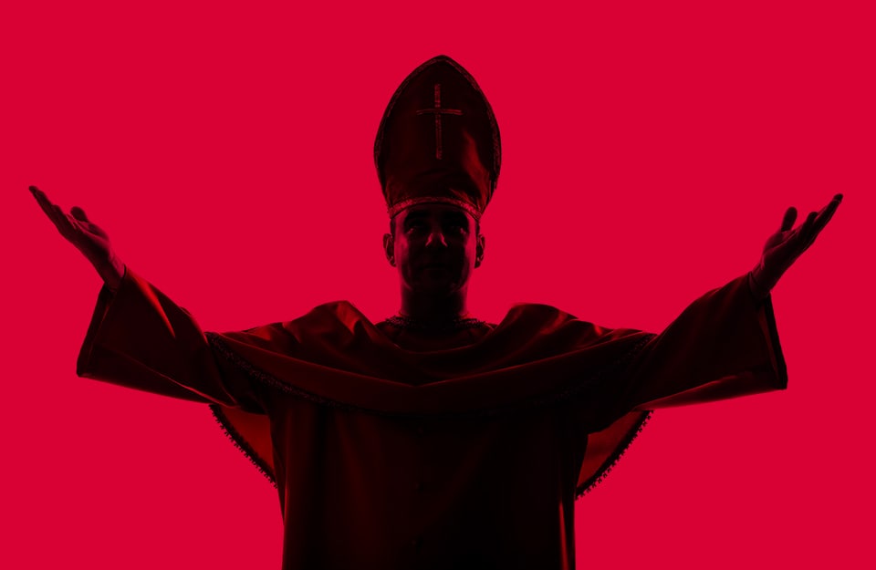 Silhouette di un cardinale a braccia aperte su sfondo rosso cardinale