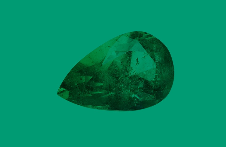 Una pietra di smeraldo su sfondo verde smeraldo