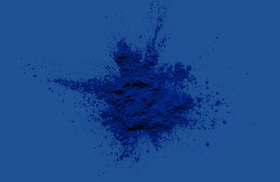 Del pigmento in polvere blu su sfondo blu