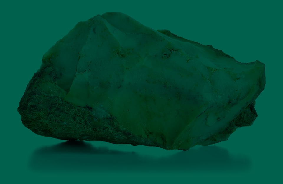 Una roccia di opale su sfondo verde scuro