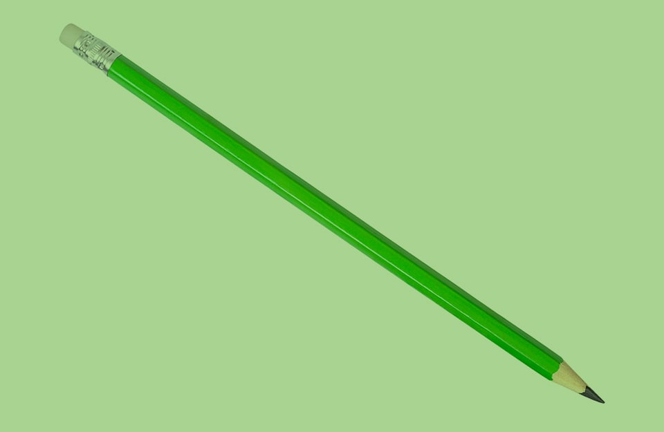 Una matita verde su sfondo verde pastello