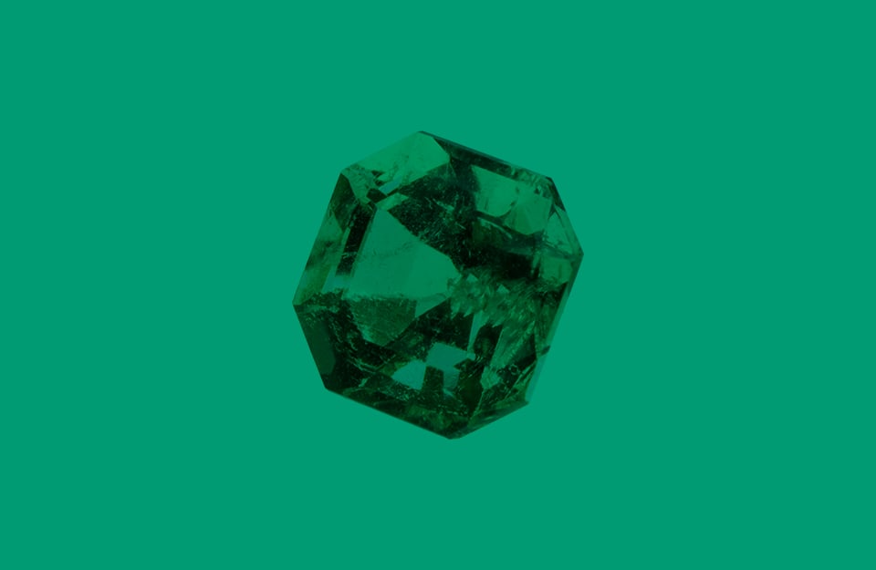 Una pietra di smeraldo su sfondo verde