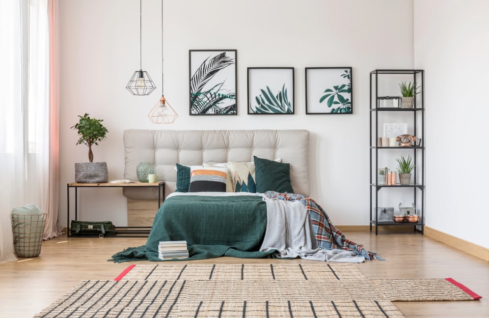 Dormitorio moderno amueblado con elementos asimétricos (alfombra, cabecero) y minimalistas (librería, lámparas de araña)