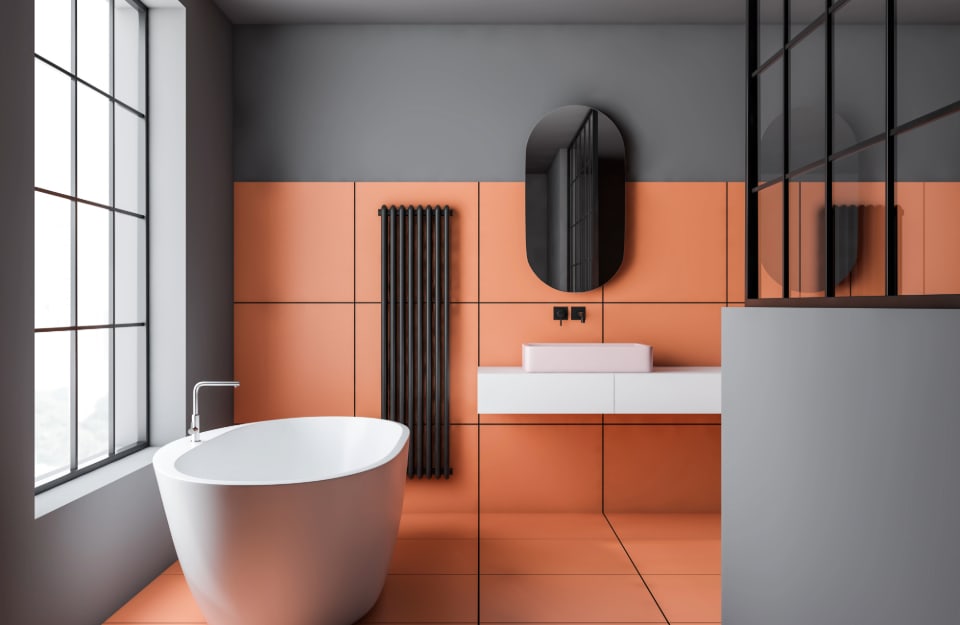 Luminoso bagno in stile minimal e contemporaneo, sui toni del grigio e dell'arancioni, con grandi piastrelle rosa-arancio sul pavimento e parte della parete