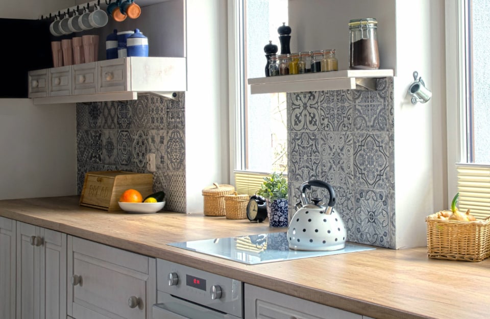Vista angolata su una cucina moderna con paraschizzi in piastrelle stile maiolica con molti pattern differenti