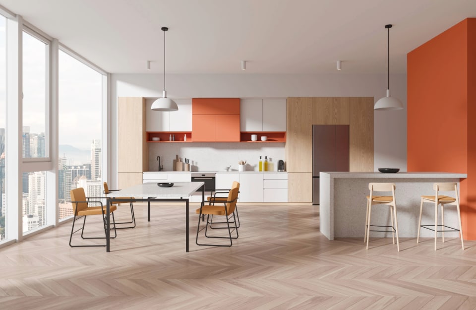 Ampio e luminoso open space con cucina e sala da pranzo, con grandi finestre a pareti e tutti sui toni del bianco, del legno chiaro e dell'arancione, usato su una singola parete e su qualche arredo