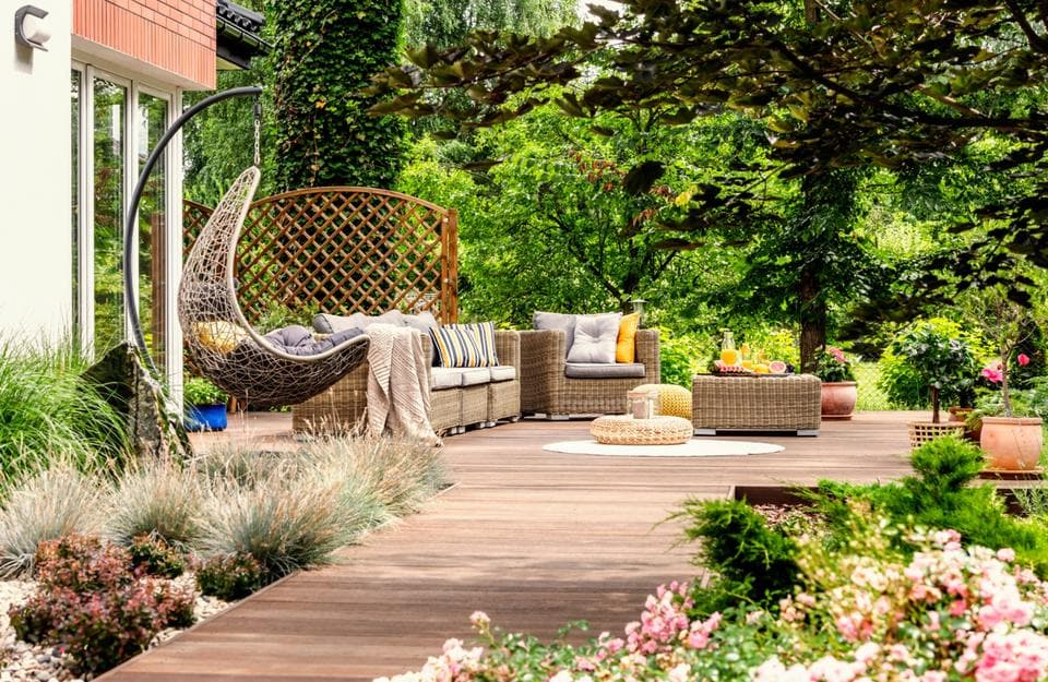 Un giardino primavere con un decking e molte piante