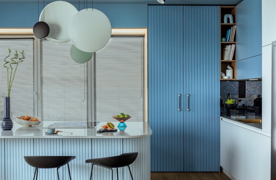 Cocina moderna azul con frentes acanalados e isla clara